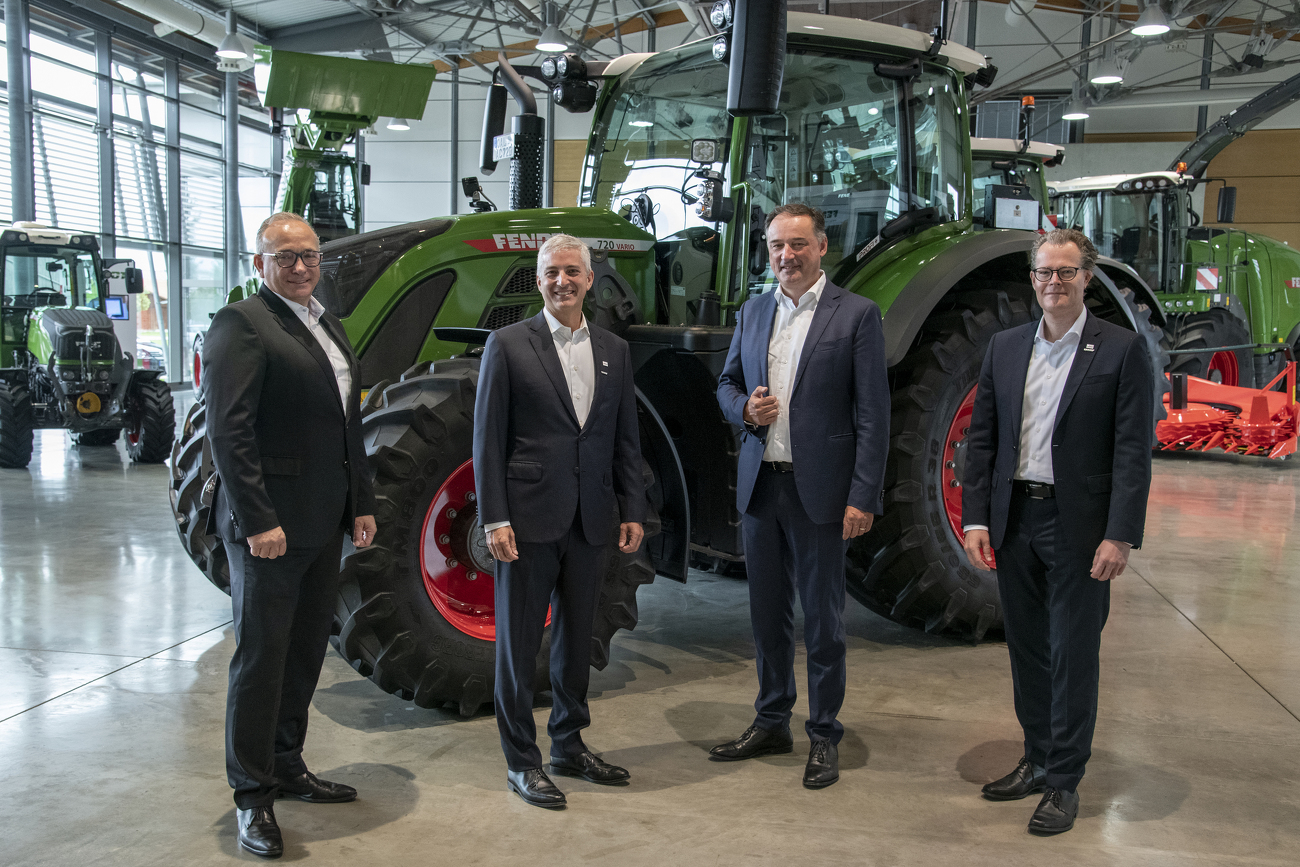 Vier Männer vor einem Fendt Traktor