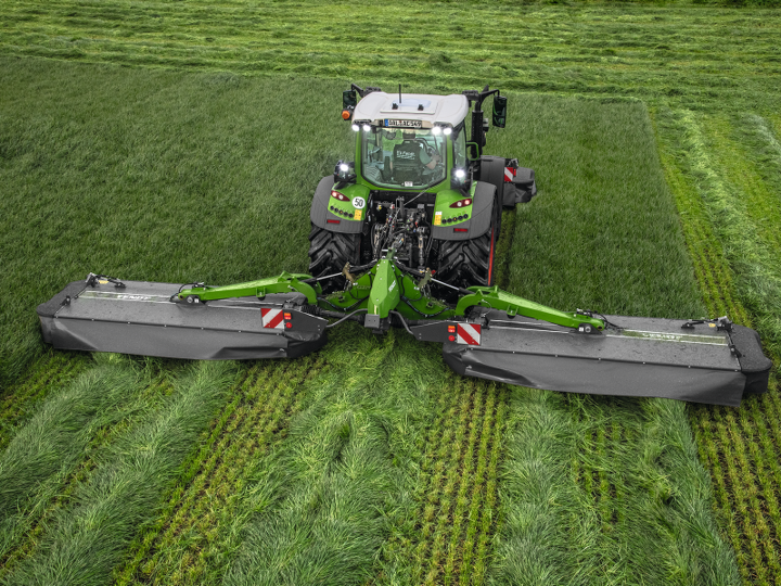 Fendt 500 Vario mit Fendt Slicer Mähwerk auf einem Feld beim Mähen.