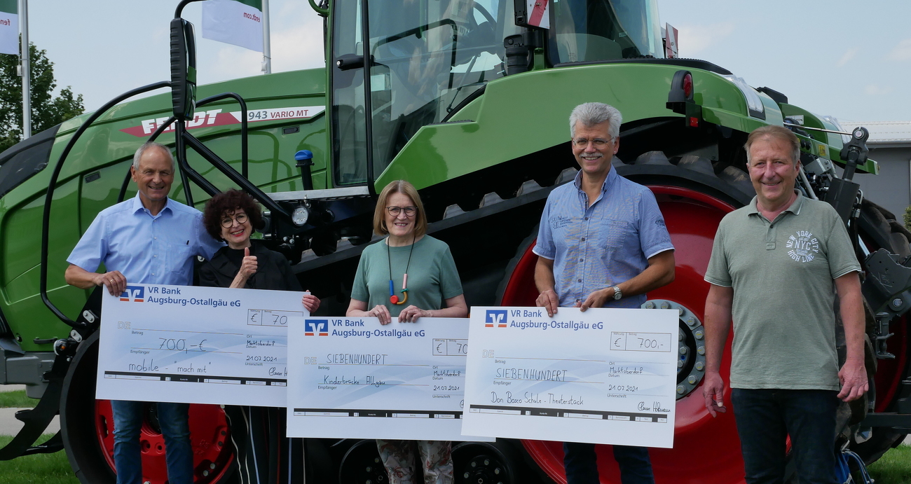 Fünf Personen stehen mit 3 Schecks in der Hand vor einem Fendt 943 Vario Raupentraktor