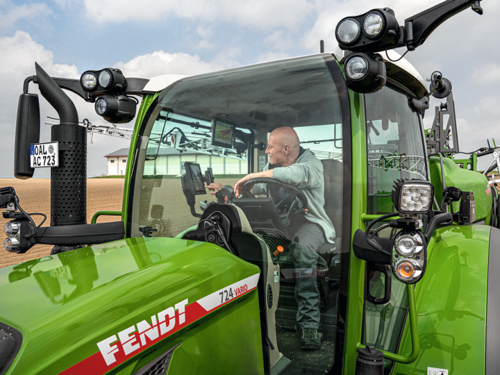 Ein Landwirt sitzt in seinem Fendt 724 Traktor und bedient das Terminal