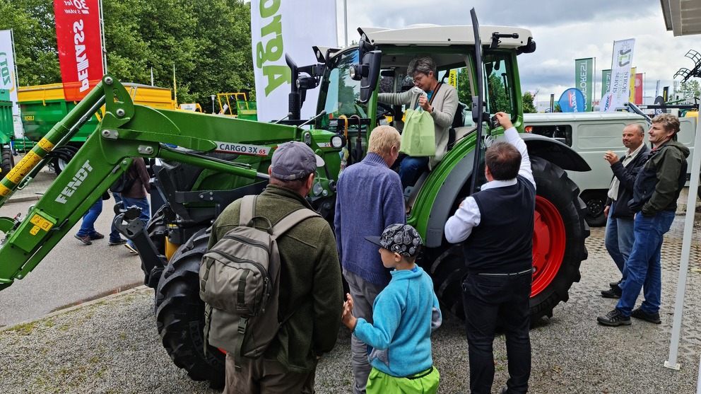 Besucher der Landwirtschaftsmesse betrachten den Fendt 211 Vario