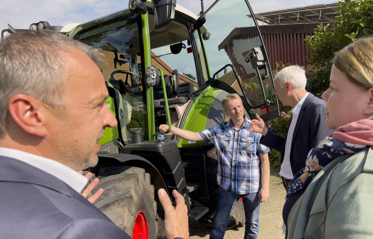 Vier Personen im Gespräch vor dem Fendt 314 Vario Traktor