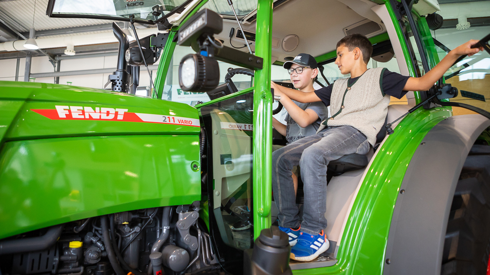 Zwei Kinder sitzen im Fendt 200 Vario.