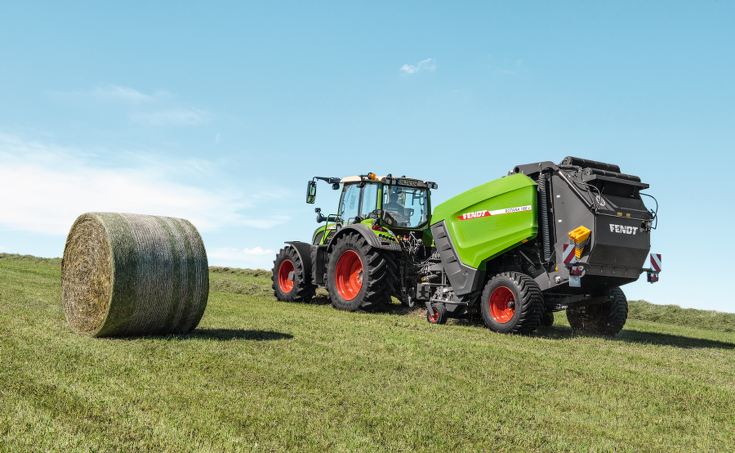 Fendt Rotana auf der Wiese mit Heuballen im Vordergrund
