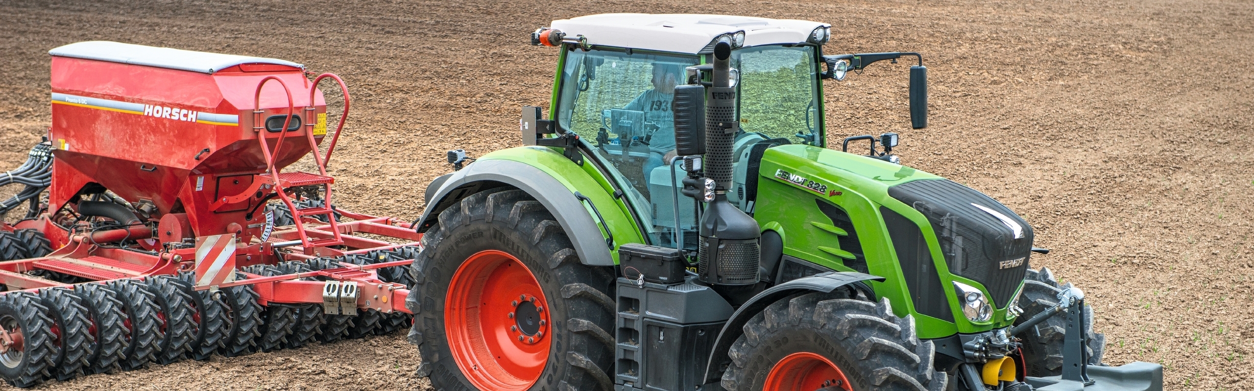 Fendt 828 Vario mit Drillmaschine auf dem Acker.