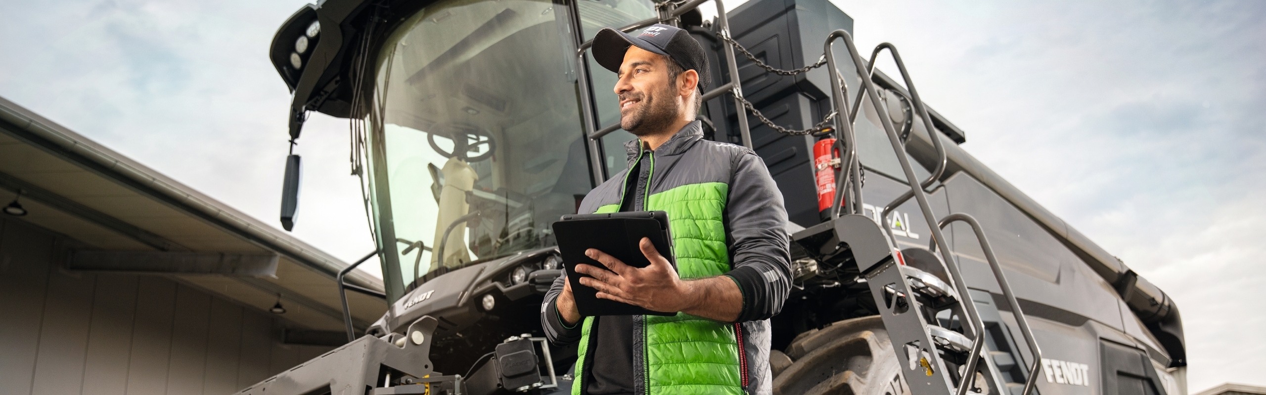 Ein schwarzer IDEAL Mähdrescher auf dem Hof eines Händlers mit einem Fendt Profi im Vordergrund