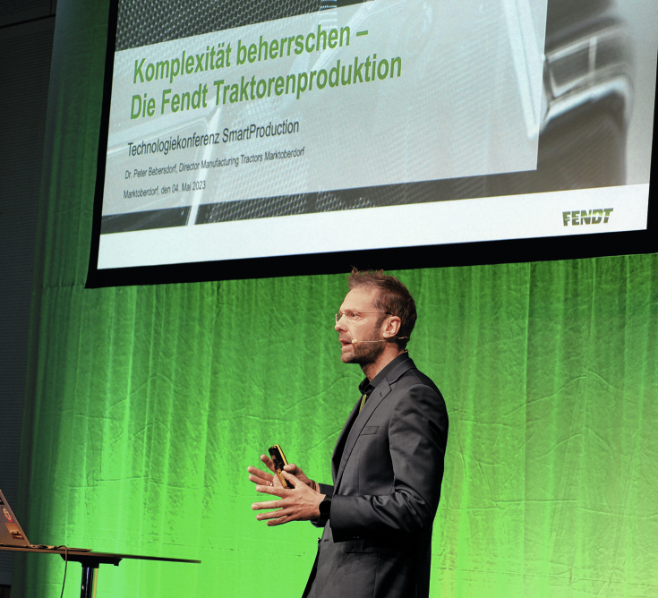 Dr. Peter Bebersdorf (Leiter Fendt Traktorenwerk) spricht auf der Bühne der SmartProduction 2023 zum Thema Komplexität beherrschen