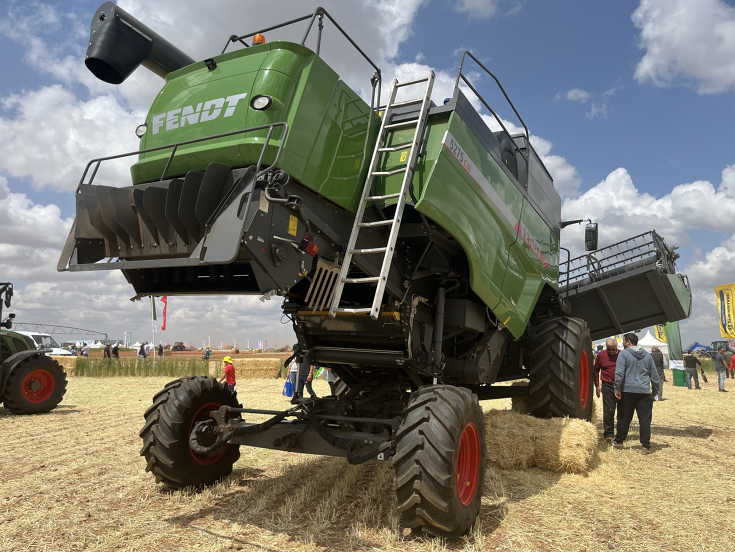 Schüttlermähdrescher der Fendt C-Serie für den Einsatz am Steilhang, ein Reifen auf einem Strohballen, schräg-gestelltes Schneidwerk