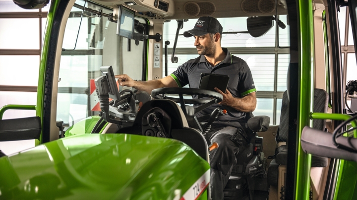 Ein Fendt Service Mitarbeiter in der Fendt Traktorkabine in der Werkstatt