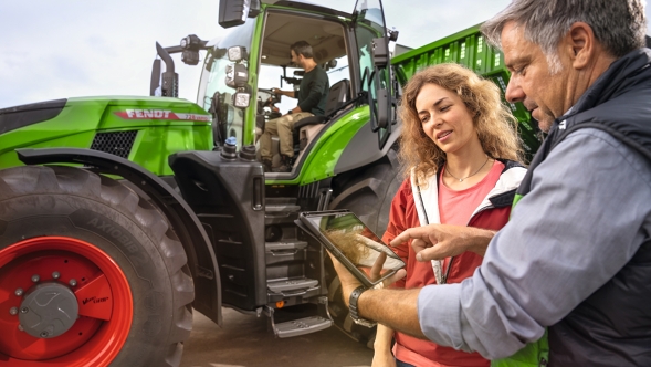 Fendt Händler mit Landwirt Ehepaar beim Vorführservice eines Fendt Traktors 700 Vario Gen7