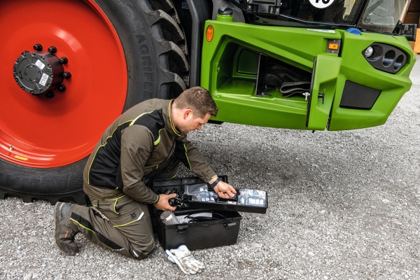 Landwirt nimmt Werkzeug aus dem Werkzeugkoffer vor dem Fendt Rogator 600 Gen2