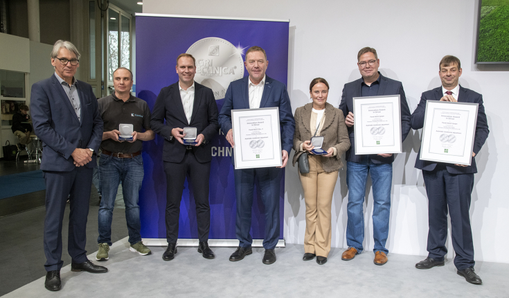 Mehrere Personen stehen mit Urkunden für ein Gruppenbild zusammen