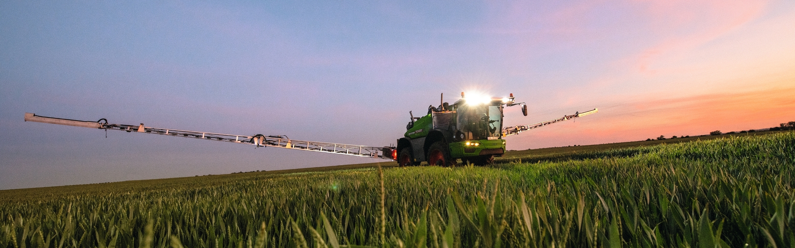 Fendt Rogator 600 Gen2 mit angehobenen Gestänge bei Sonnenuntergang