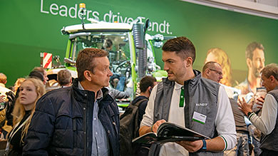 Ein Fendt Mitarbeiter berät einen interessierten AGRITECHNICA Besucher