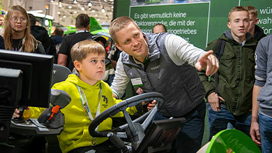 Ein Junge promiert den Farming Simulator auf der AGRITECHNICA 2023 aus