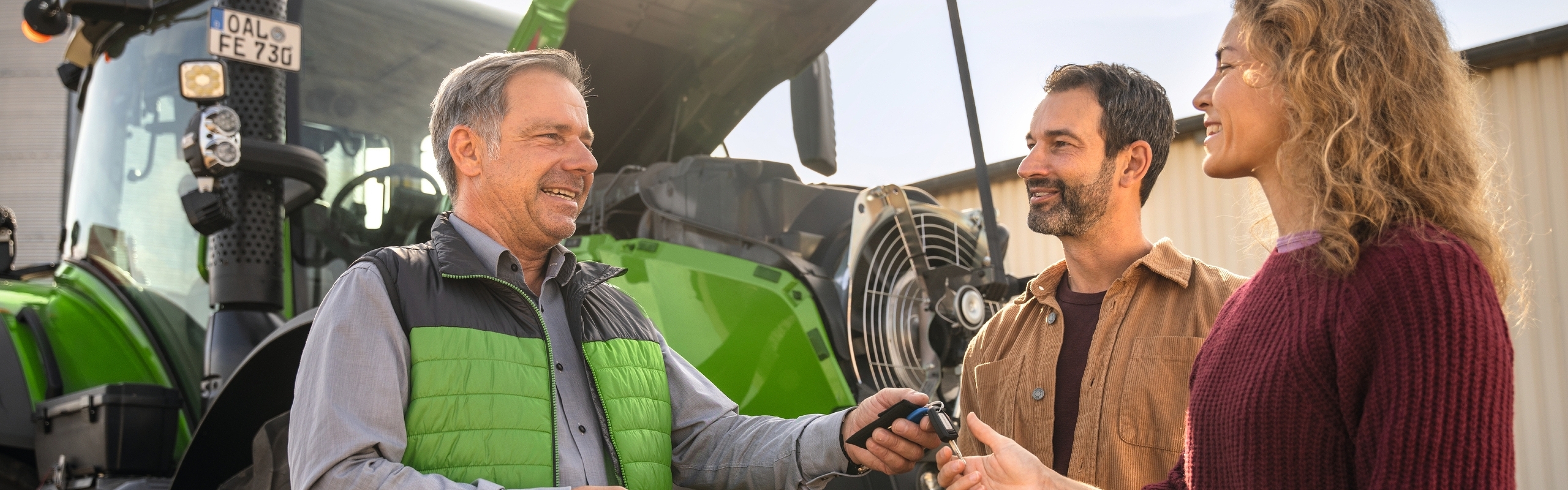 Landwirte erhalten Traktorschlüssel vom Händler beim Fahrertraining