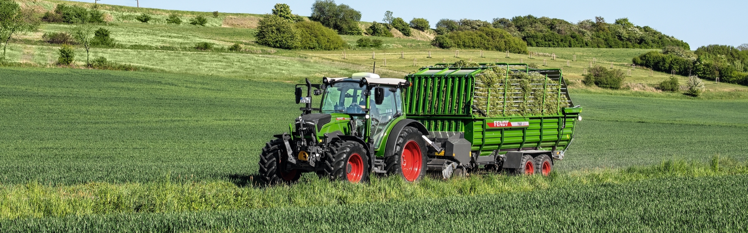Fendt Vario 200 auf einer Wiese mit einem beladenen Fendt Tigo.