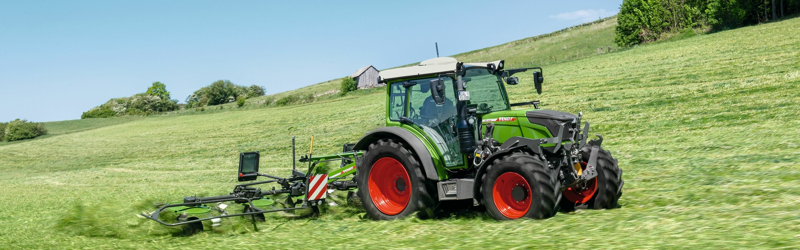 Fendt 200 Vario mit Fendt Twister im Grünland im Einsatz am Hang