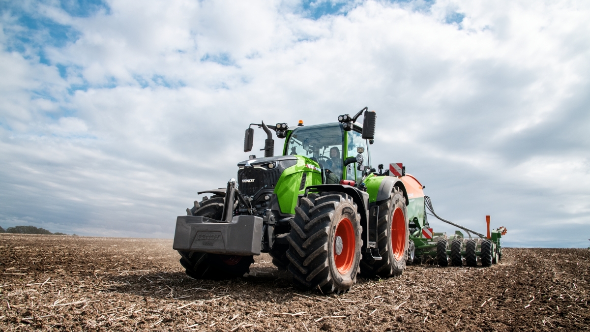 Eine Landwirtin fährt mit einem Fendt 700 Vario Gen7 und einer Amazone Drillmaschine auf dem Acker.