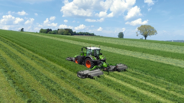 Ein grüner Fendt Traktor mit der Slicer Mähkombination 860KC und 310F KC bei der Grünlandernte