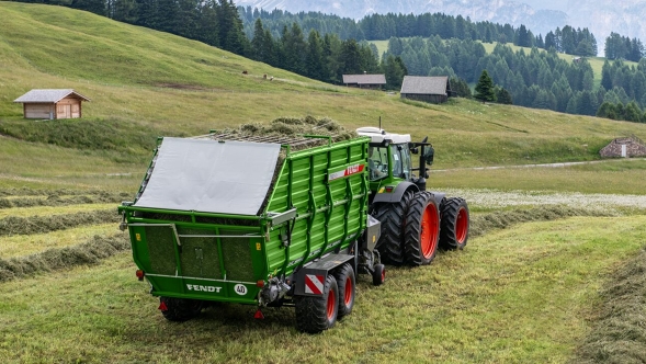 Ein Gespann bestehend aus den typisch grün lackierten Fendt Traktor und Fendt Tigo Ladewagen im alpinen Einsatz