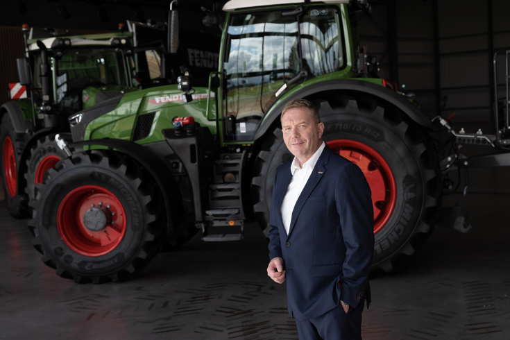 Christoph Gröblinghoff, Vorsitzender der Fendt Geschäftsführung, im Anzug vor einem Fendt Traktor, leicht von der Seite fotografiert