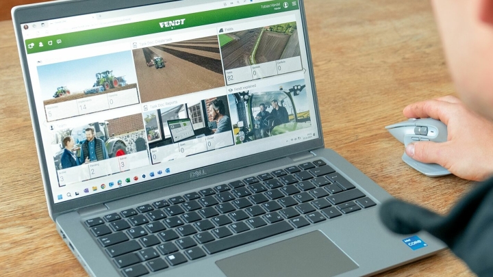 Ein Mann bedient mit einer Maus ein geöffnetes Notebook, das auf einem hellbraunen Holztisch steht. Auf dem Bildschirm ist die Plattform FendtOne Offboard geöffnet, die verschiedene Daten anzeigt.