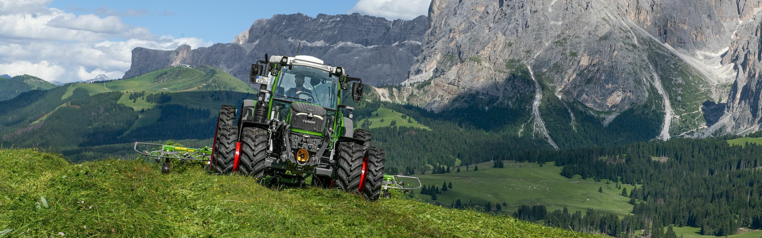Ein grün lackierter Fendt 200 Vario im alpinen Einsatzgebiet bei der Grünfutterernte