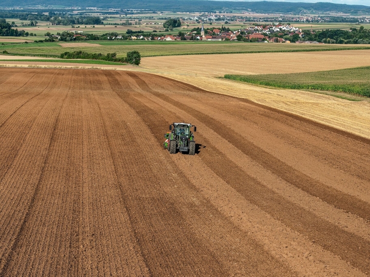 Ein Traktor fährt über den Acker.