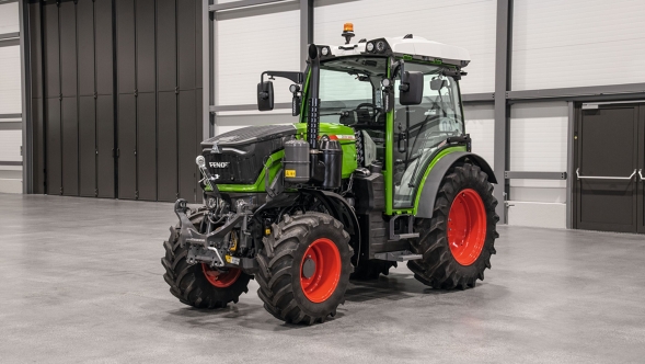 Der grüne Fendt 200 V/F/P Vario mit den roten Felgen steht in einer Halle mit grauem Boden.