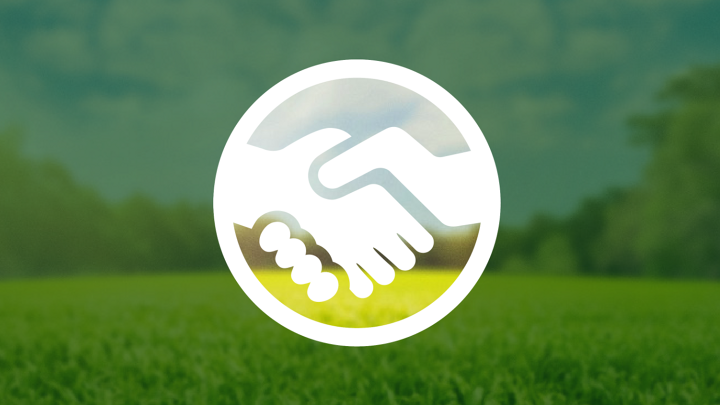 Eine weiße Abbildung eines Handschlags befindet sich innerhalb eines Kreises. Der Hintergrund zeigt eine grüne Waldwiese unter blauem Himmel, welche außerhalb des Kreises durch einen dunkelgrünen, teiltransparenten Layer abgedunkelt ist.