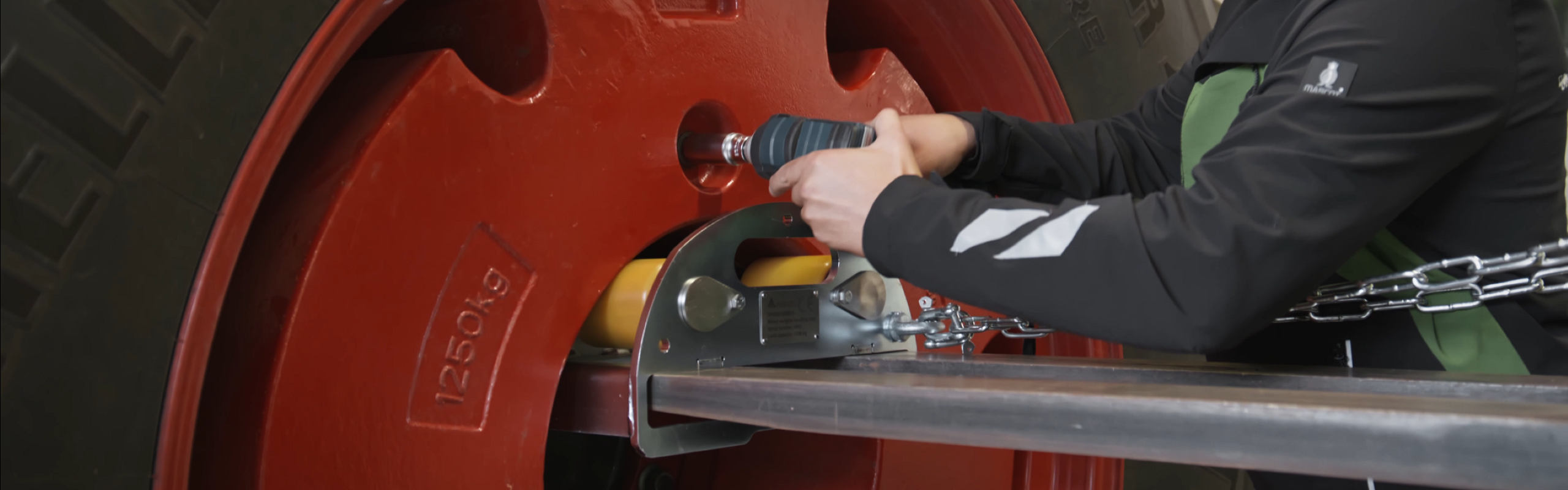 Ein Fendt Servicemitarbeiter montiert ein rotes Radgewichtstool an einem Fendt Traktor.