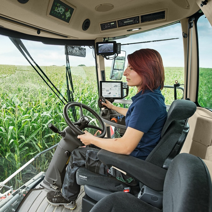 Eine Landwirtin sitzt in ihrem Fendt Katana und steuert die Maschine durch ein Maisfeld.