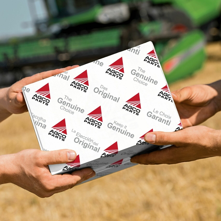 Übergabe eines AGCO Parts Paketes auf dem Feld.