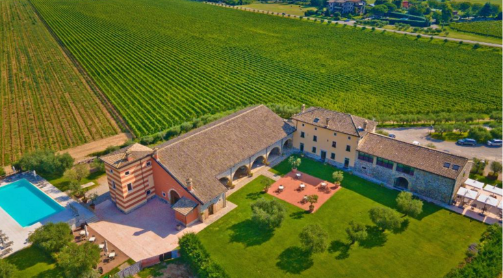 Luftaufnahme eines italienischen Weinguts im Hintergrund lange Reihen mit Weinreben