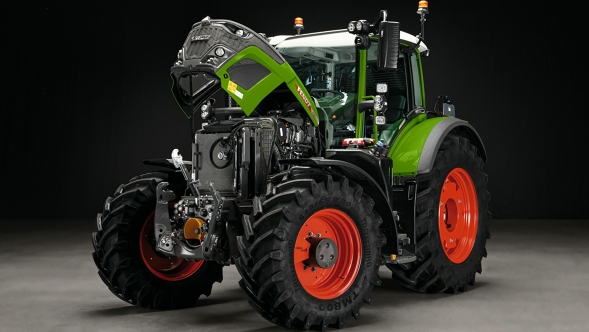 Der grüne Fendt 600 Vario mit roten Felgen steht mit offener Motorhaube auf einem grauen Boden. Der Hintergrund ist schwarz.