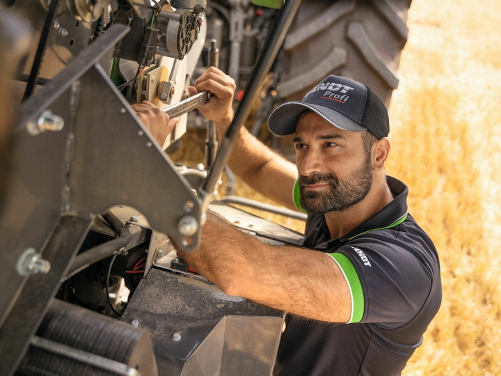Ein Fendt Service-Techniker direkt auf dem Feld im Einsatz an der Erntemaschine