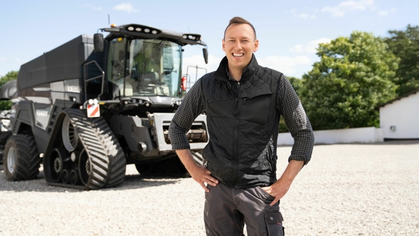 Mark Jacobsen vor seinem schwarzen Fendt IDEAL Mähdrescher auf seinem Hof