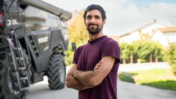 Lohnunternehmer Ivan Tosi neben seinem schwarzen Fendt IDEAL 8 T auf seinem Betriebsgelände