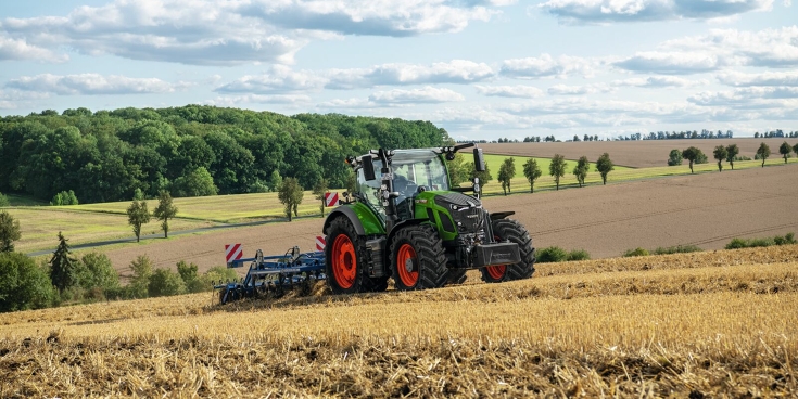 Ein grüner Fendt 620 Vario Traktor fährt mit Anbaugerät über ein Stoppelfeld zur Bodenbearbeitung