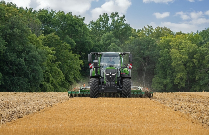 Der Fendt 620 Vario erreicht Bestwerte auf dem Feld im DLG PowerMix Test Ein grüner Fendt 620 Vario fährt mit einer Scheibenegge über ein Stoppelfeld im Hintergrund ein Wald mit grünen Bäumen.