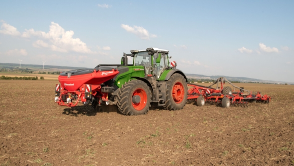 Ein grüner Fendt 1000 Vario Traktor fährt mit verschiedenen Front- und Heckgeräten über ein Feld