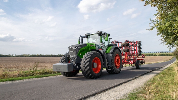 Ein Fendt 1000 Vario auf einer Landstraße neben einem Feld