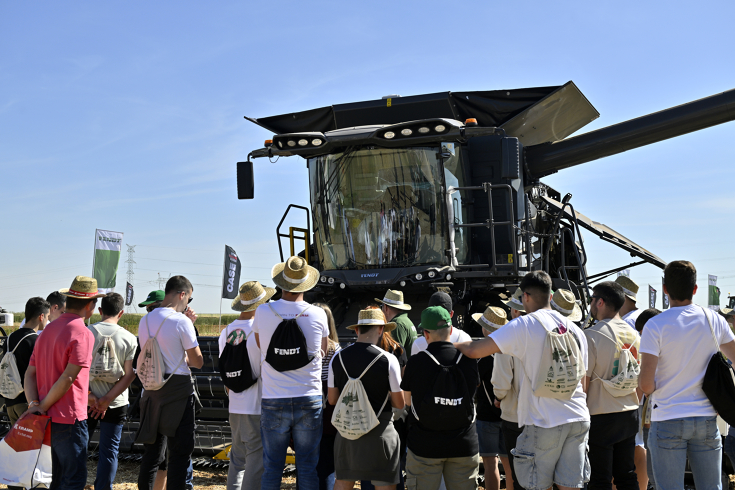 Ein graphit-farbener Fendt IDEAL 7 PL umringt von einer Menschenmenge mit Sommerkleidung