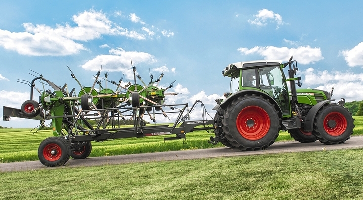 Ein grüner Fendt Traktor mit dem grünen Fendt Twister fahren auf einer Straße
