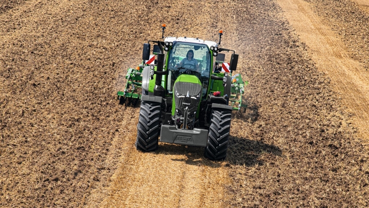 Der grüne Fendt 700 Vario bei der Bodenbearbeitung eines Ackers mit einem Bodenbearbeitungsgerät.