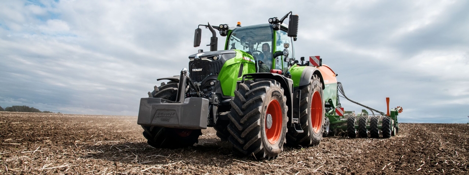 Eine Frau fährt mit einem Fendt 700 Vario Gen7 auf einem Acker