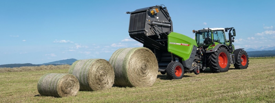 Die Fendt Rundballenpresse Rotana 160 V hinter einem Fendt Traktor gespannt im Feldeinsatz, um