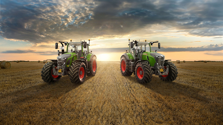 Der grüne Traktor Fendt 600 Vario und Fendt 700 Vario Gen7 stehen auf einem großen Feld mit einer untergehenden Sonne im Horizont