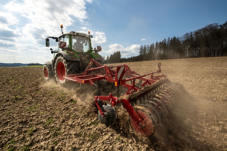 Fendt 300 Vario im Ackereinsatz Ein grüner Fendt 300 Vario arbeitet mit einem Horsch Grubber auf dem Acker.